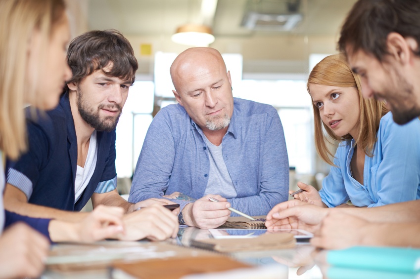 three people sitting at a table making decisions
