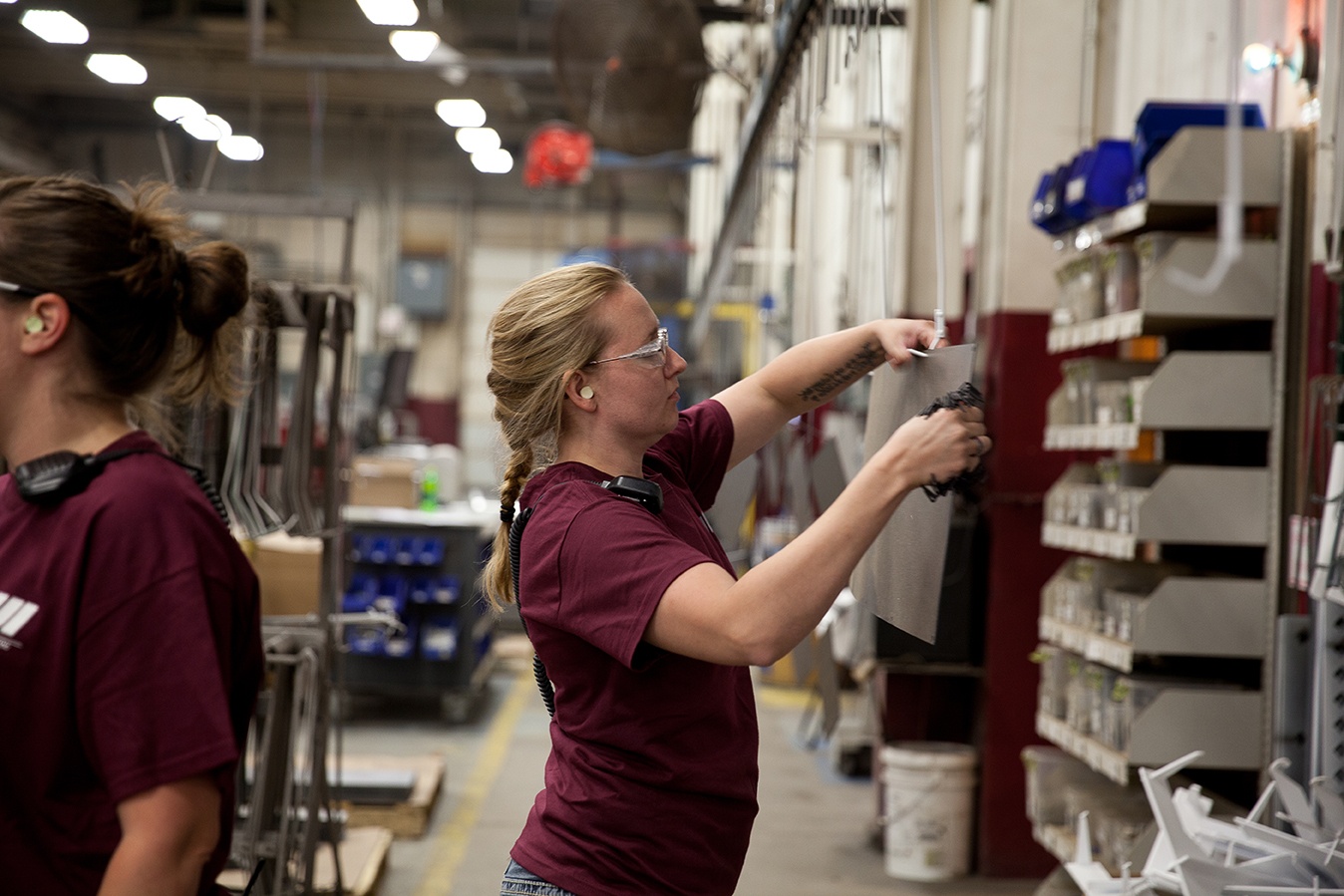 woman applying powder coat in-house
