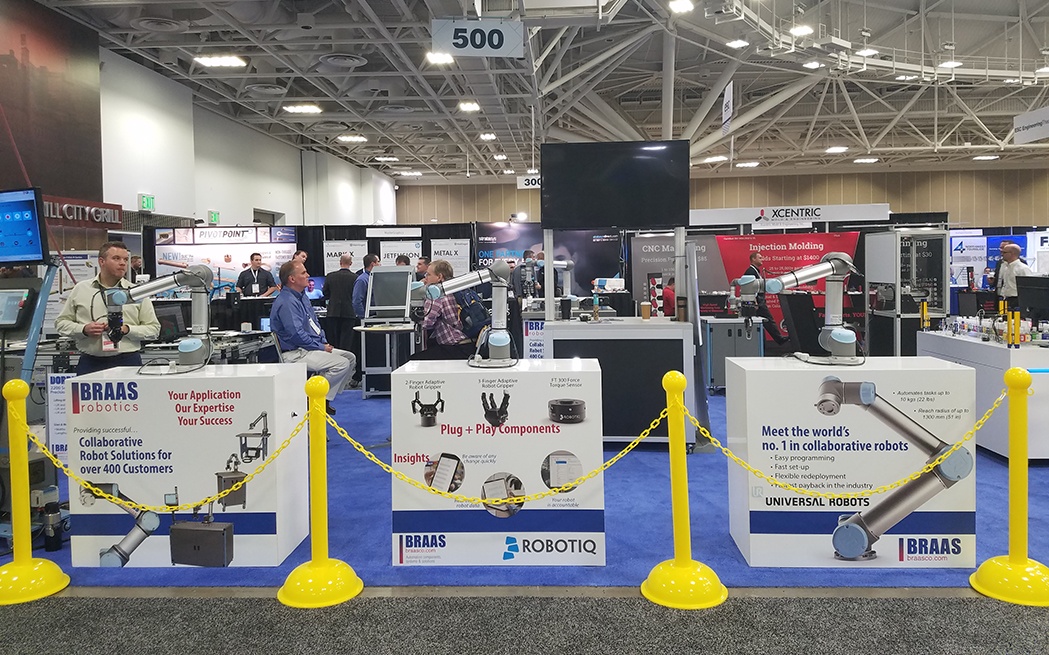 trade show booth featuring robotic arms for manufacturing