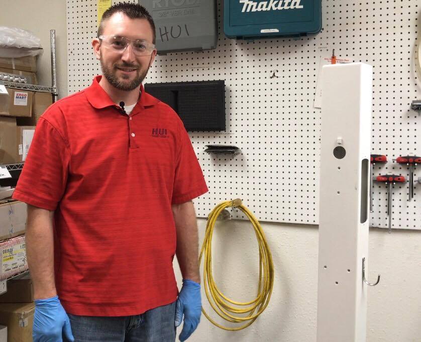 HUI employee Nick standing next to medical cart