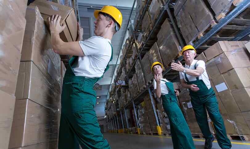 man mishandling packaging box with coworkers reaching out to help