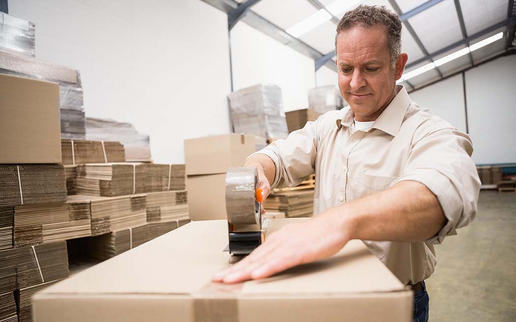 man in warehouse packaging box