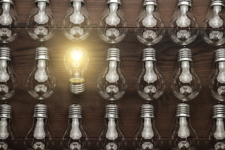 many lightbulbs on the table and only one has light